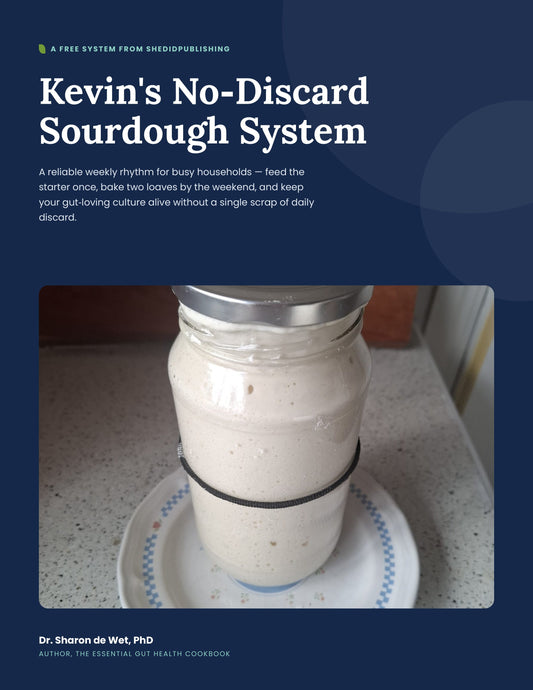 Kevin the sourdough starter, freshly fed and rising in a glass jar on a blue-checked plate